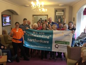 Boulters Residents and Staff holding a we are outstanding banner