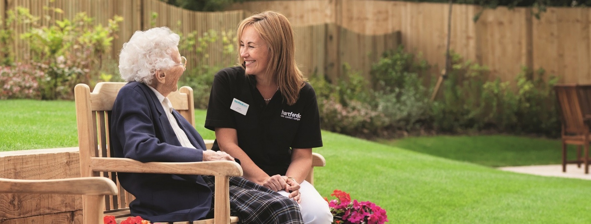 Care assistant and patient chatting on a bench