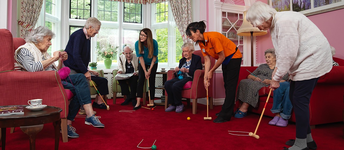 Several residents and staff playing indoor croquet