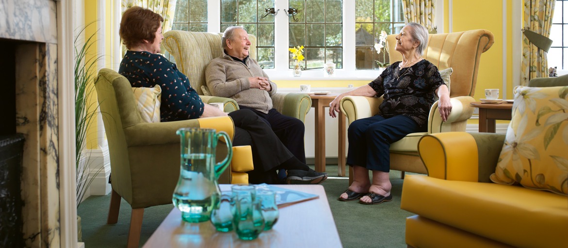 three residents sat chatting in the main lounge