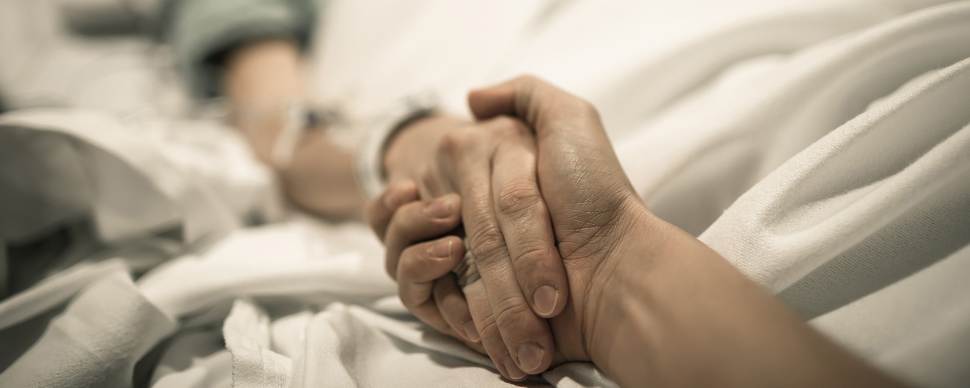 Carer holding hands with resident for end of life