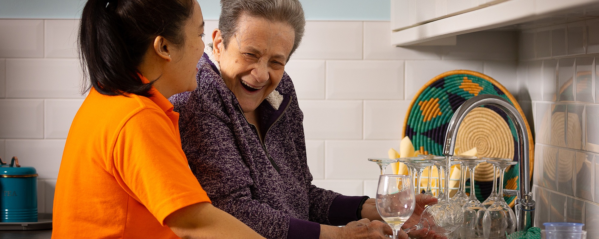 Resident at Ashley Grange Does Washing Up Laughing With Carer