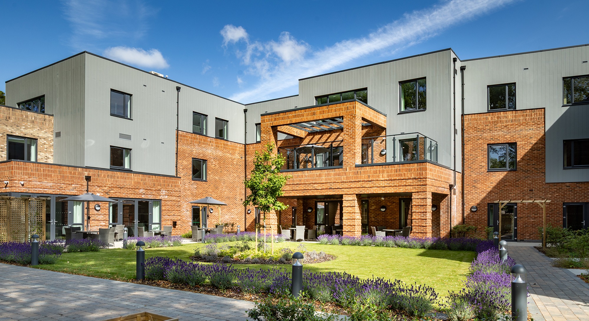 Moorhill Care Home building bathed in sunlight as seen from the garden, highlighting the bright, welcoming exterior