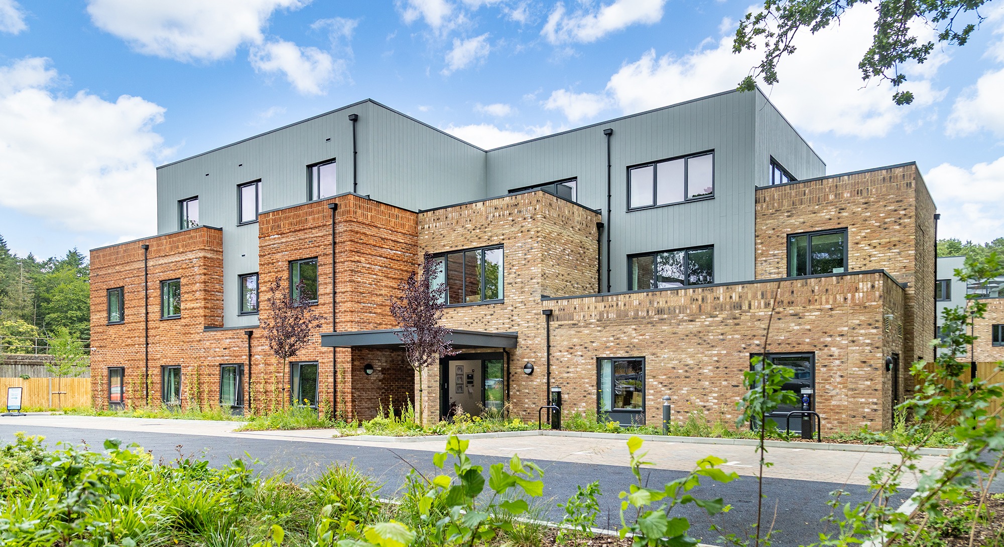 The front of Moorhill Care Home building viewed from the car park, showcasing the modern exterior and entrance