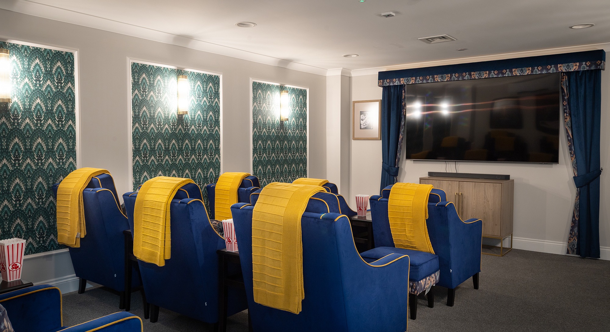 View from the back of Moorhill’s cinema room, showing plush chairs facing a large screen ready for a film experience